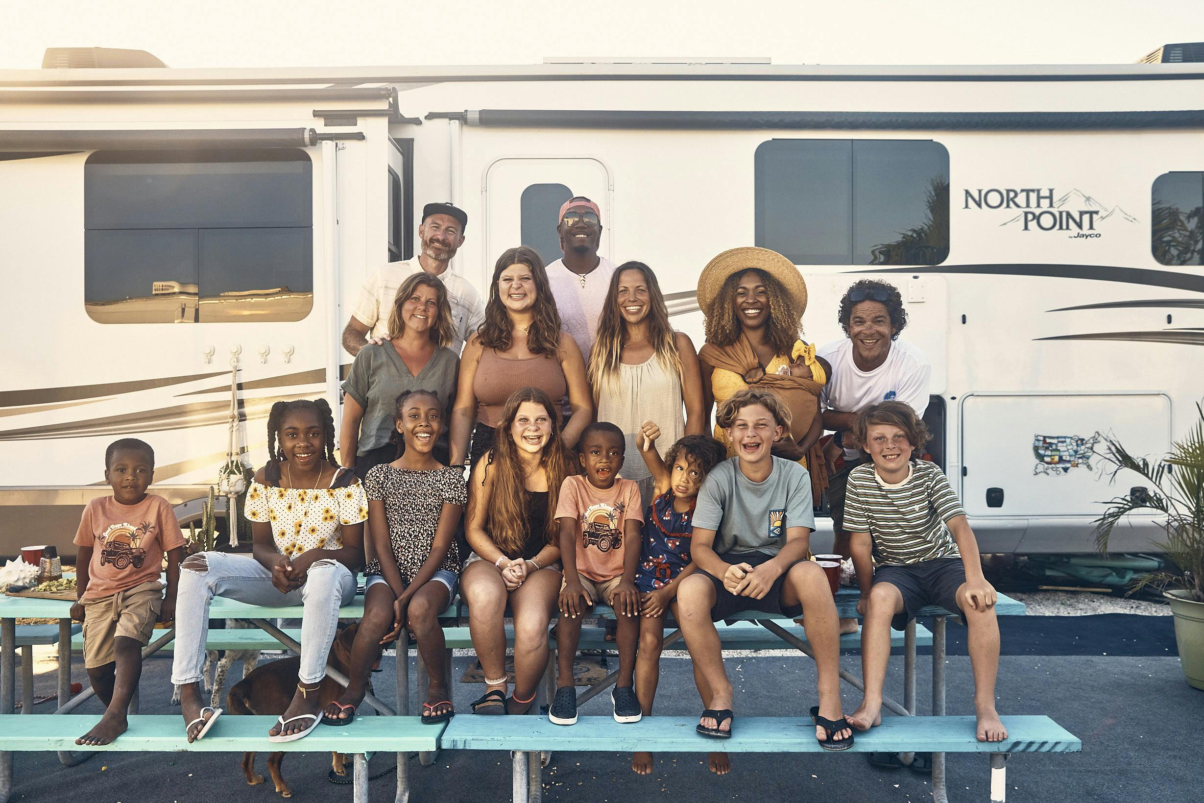 The Lanes and their friends smile for a group photo in front of an RV