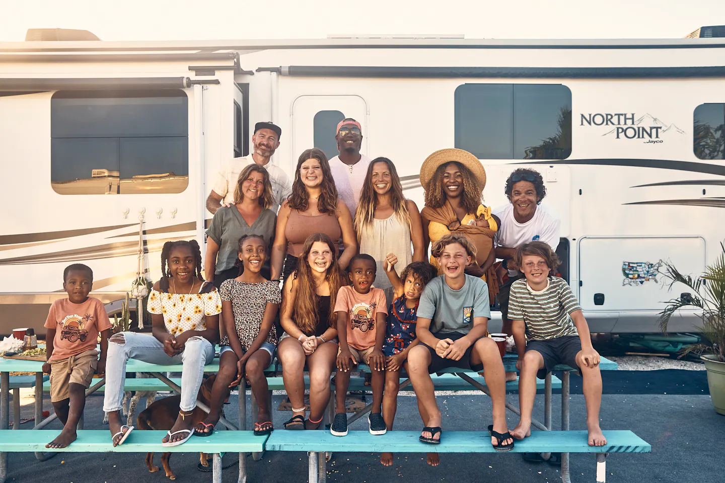 The Lanes and their friends smile for a group photo in front of an RV