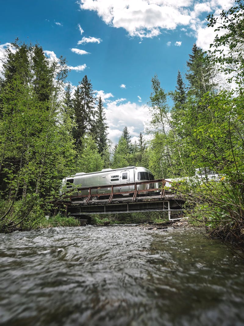 An airstream travel trailer driving over a bridge