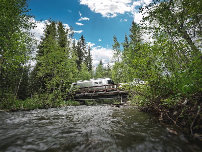An airstream travel trailer driving over a bridge