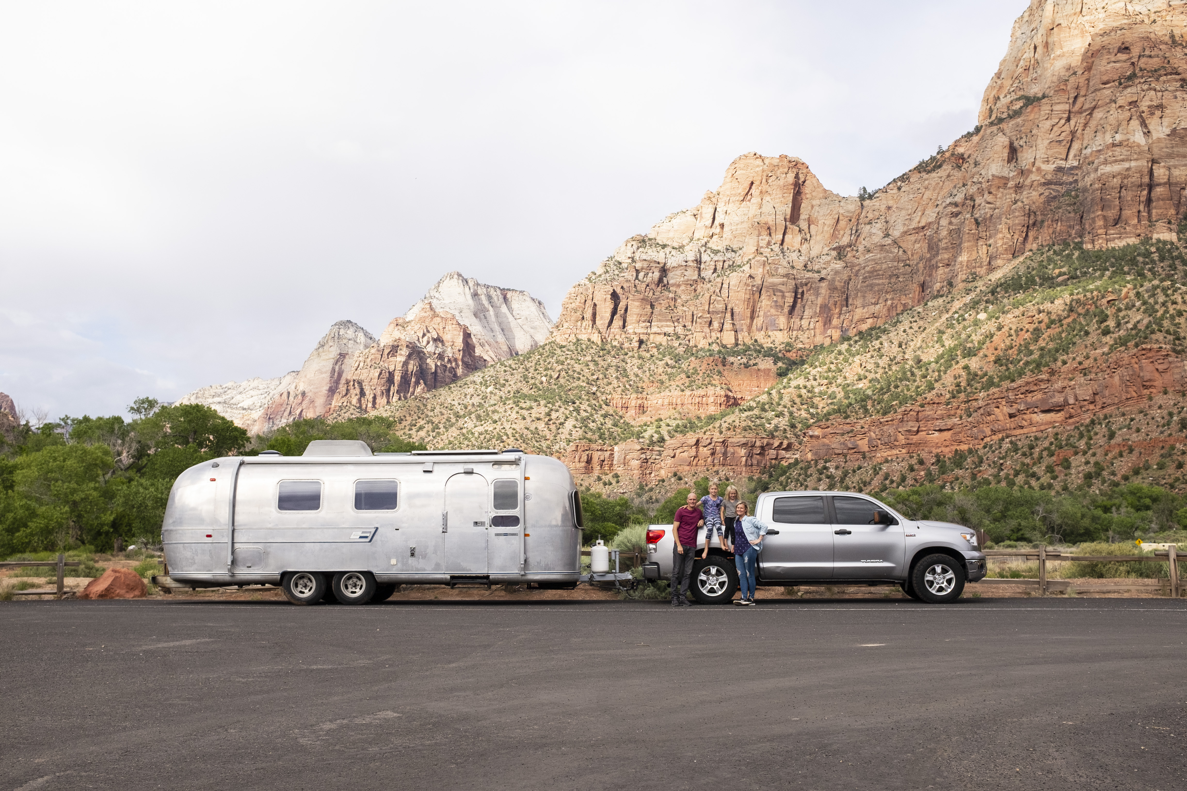 The Wells family posed with the family Airstream in front of rocky hills. 