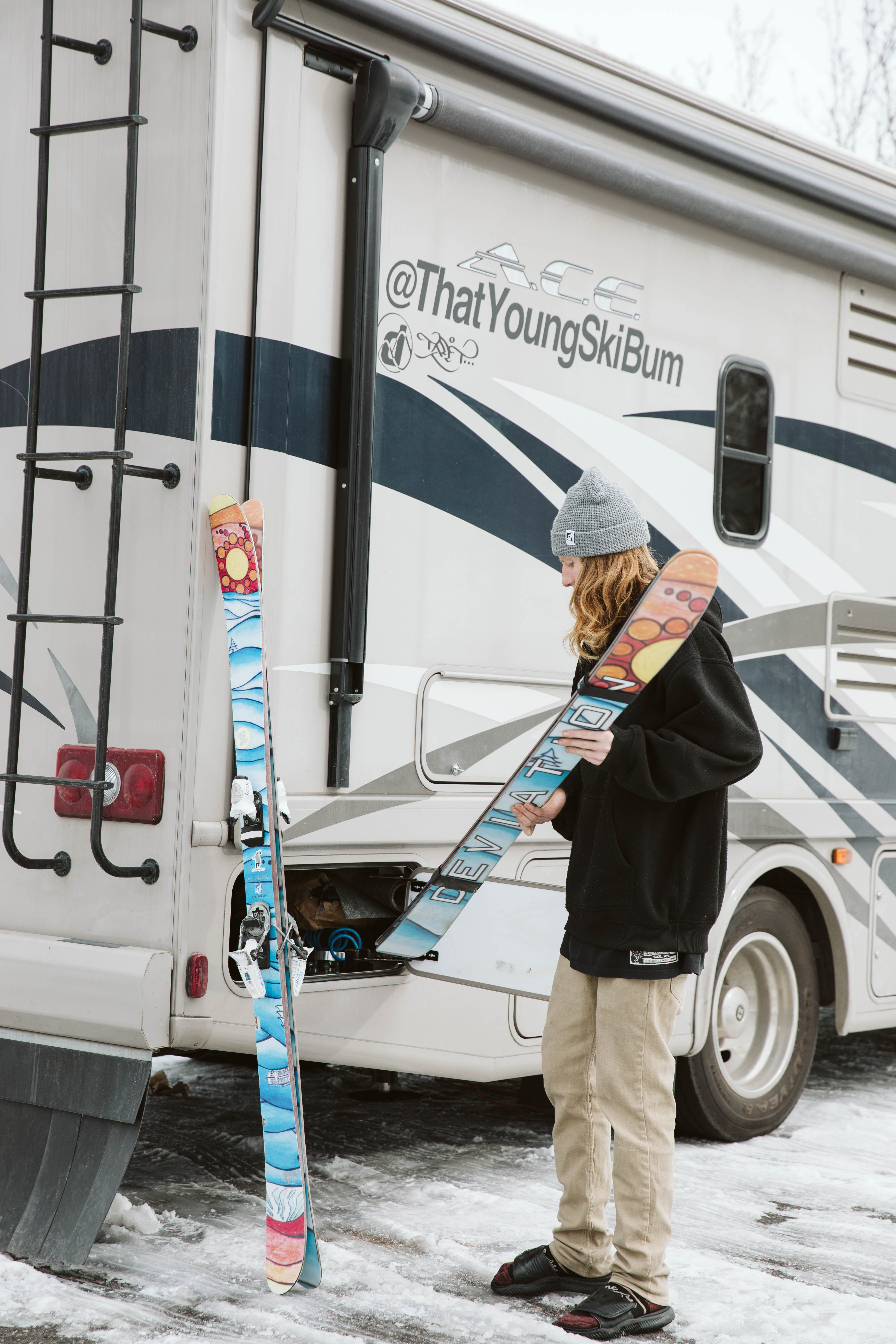Packing skis into outside cubbies in an RV. 