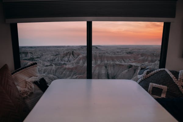 A sunset view out an RV window, facing the landscape of Badlands National Park. 