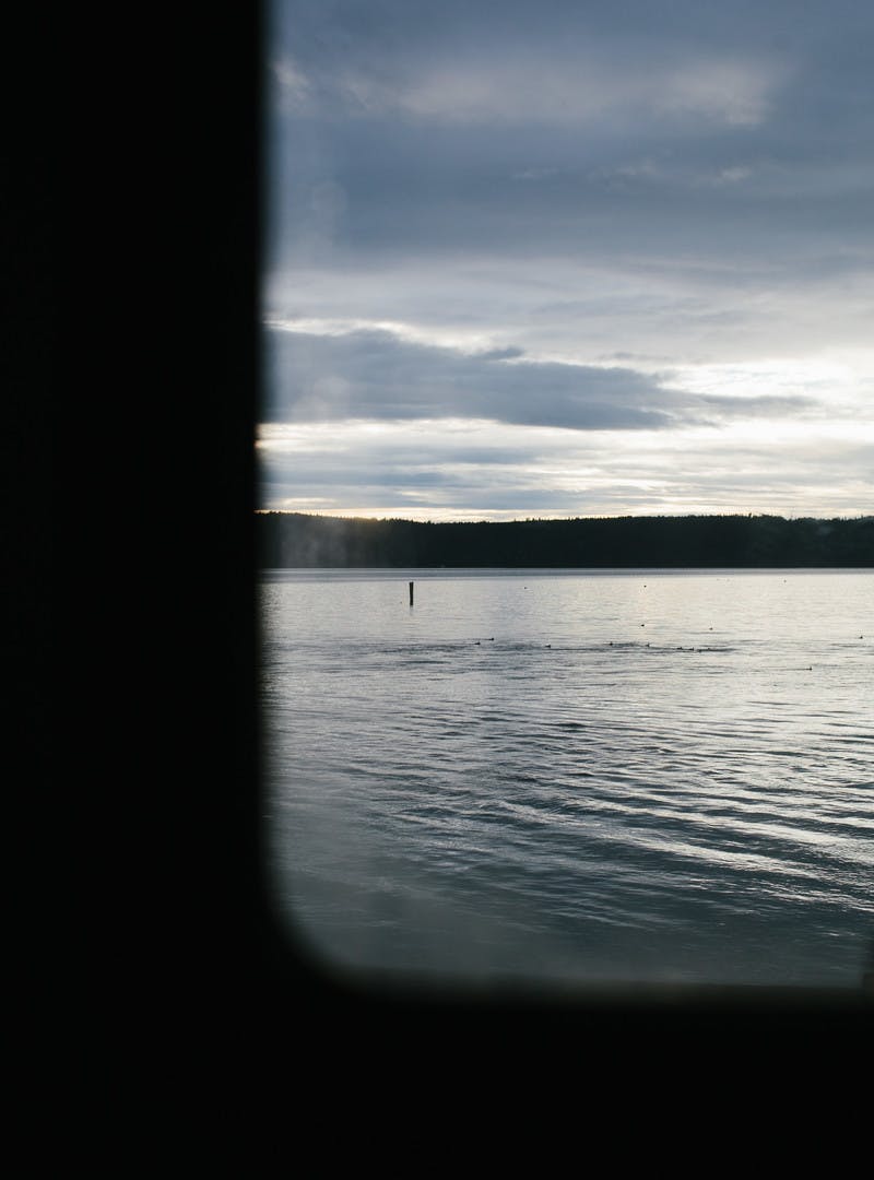 A shot of a peaceful lake through an RV window. 
