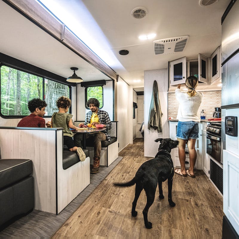 A family sits at a dinette inside of a Trail Runneer