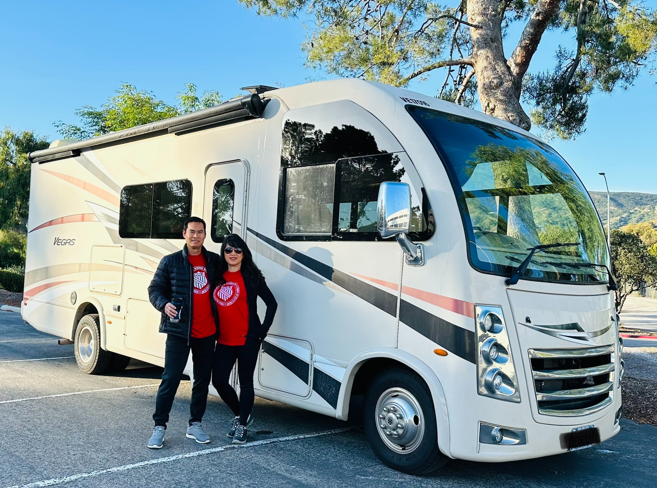 Brenda Huynh and Tiger Doan standing outside their Thor Motor Coach Vegas Class A motorhome