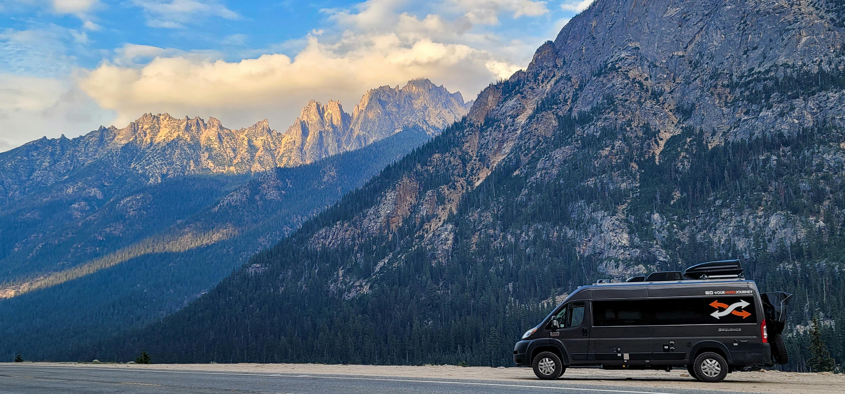 Gabe and Rocio's TMC Sequence parked in a National Forest overlooking mountains and a blue sky