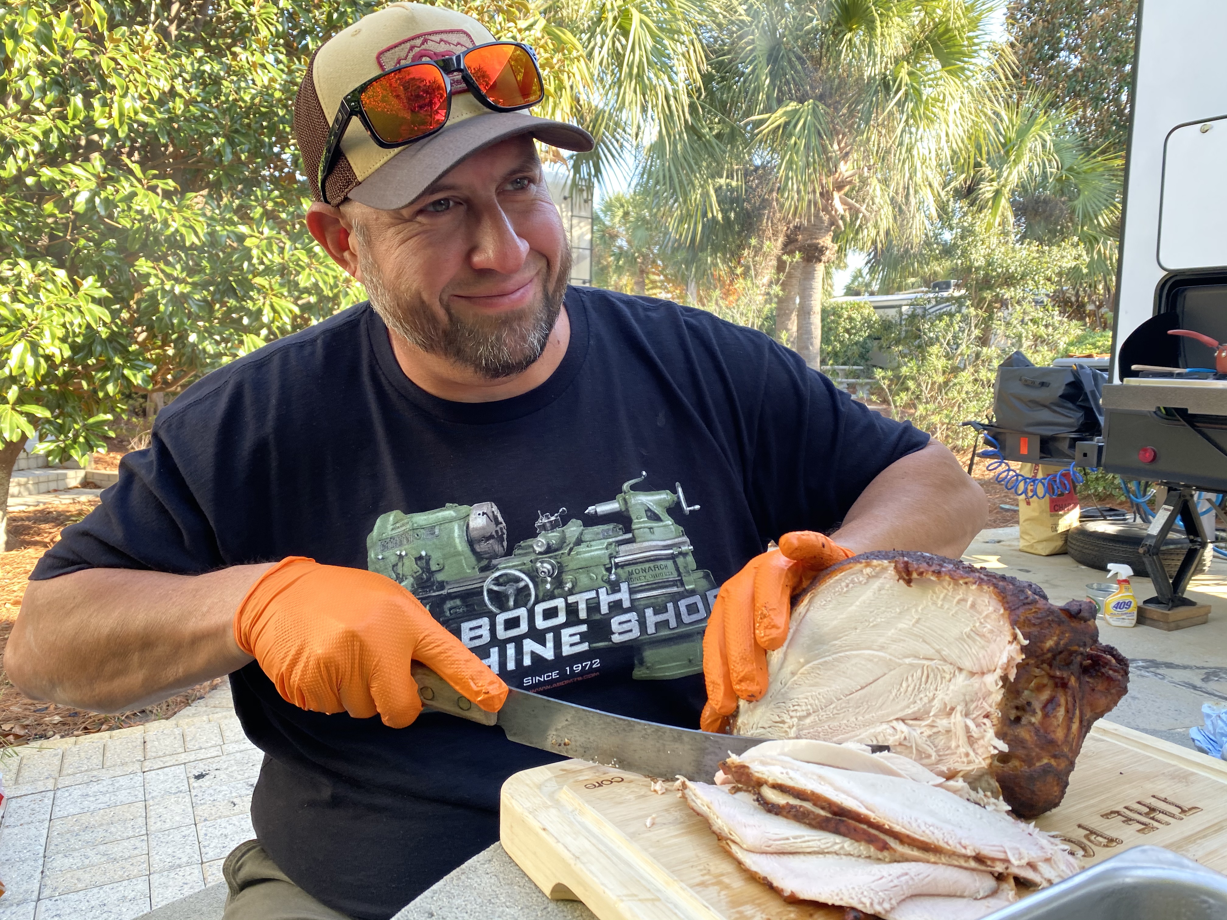Abby Booth's husband cuts into a Turkey for thanksgiving outside their Dutchmen Kodiak travel trailer. 