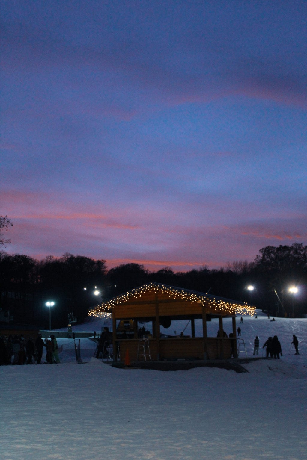 Cascade Mountain ski lodge with lights and snow with a sunset