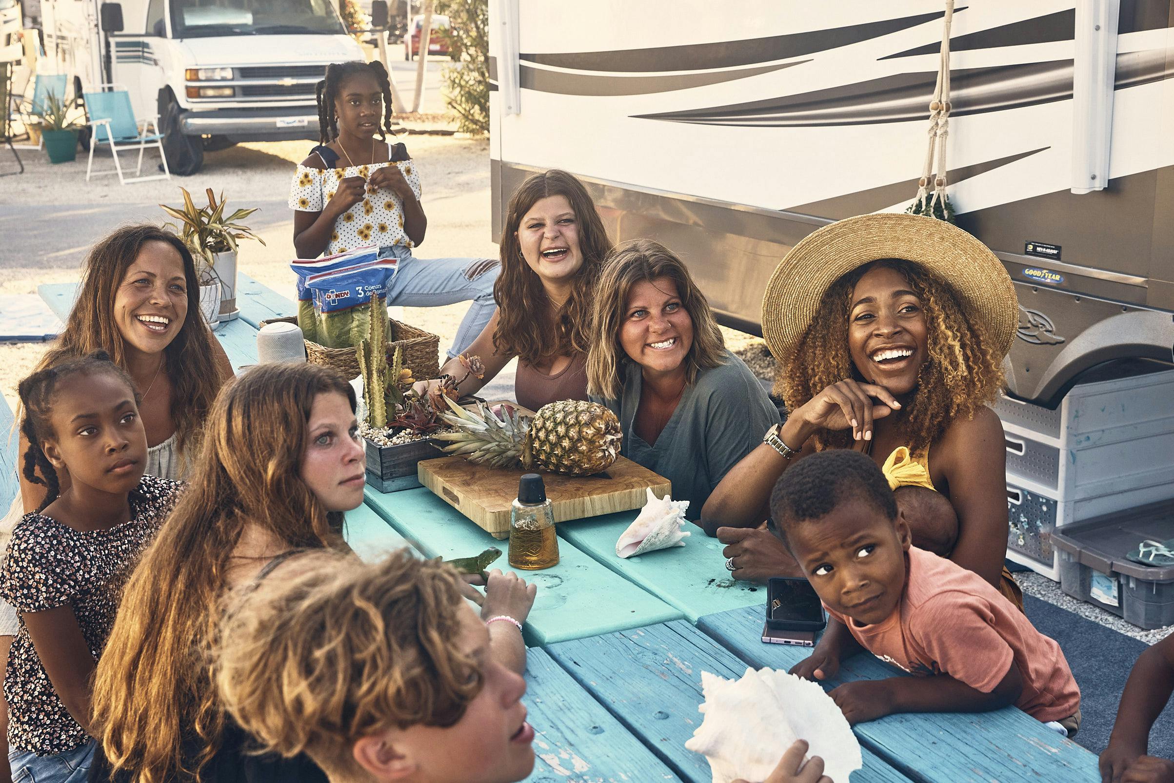 The Lane family and their friends sit around a picnic table 