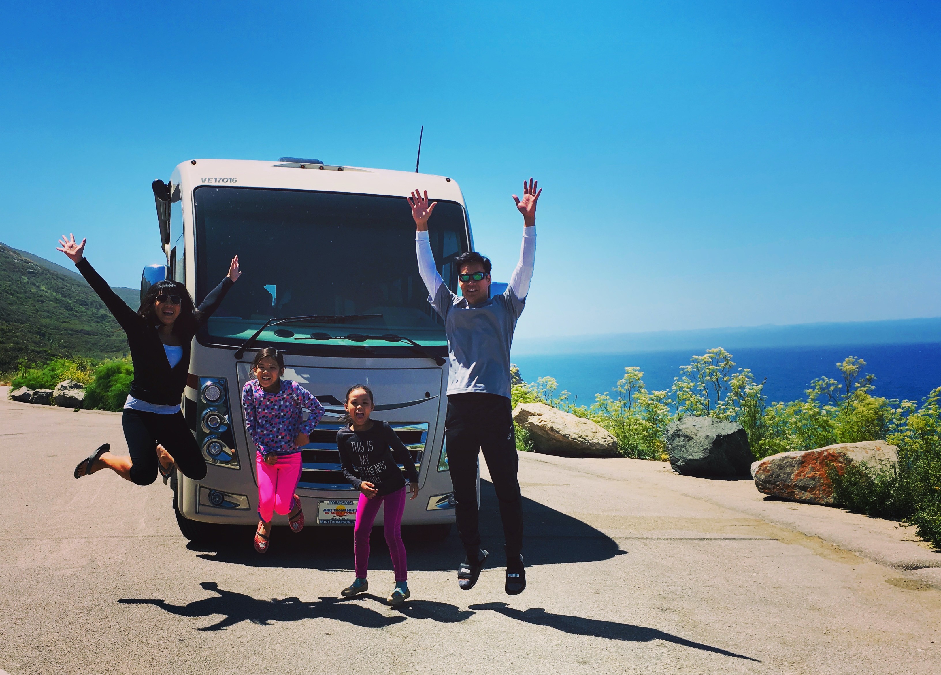 Brenda Huynh & Tiger Doan and their family jumping in front of their thor Motor Coach vegas