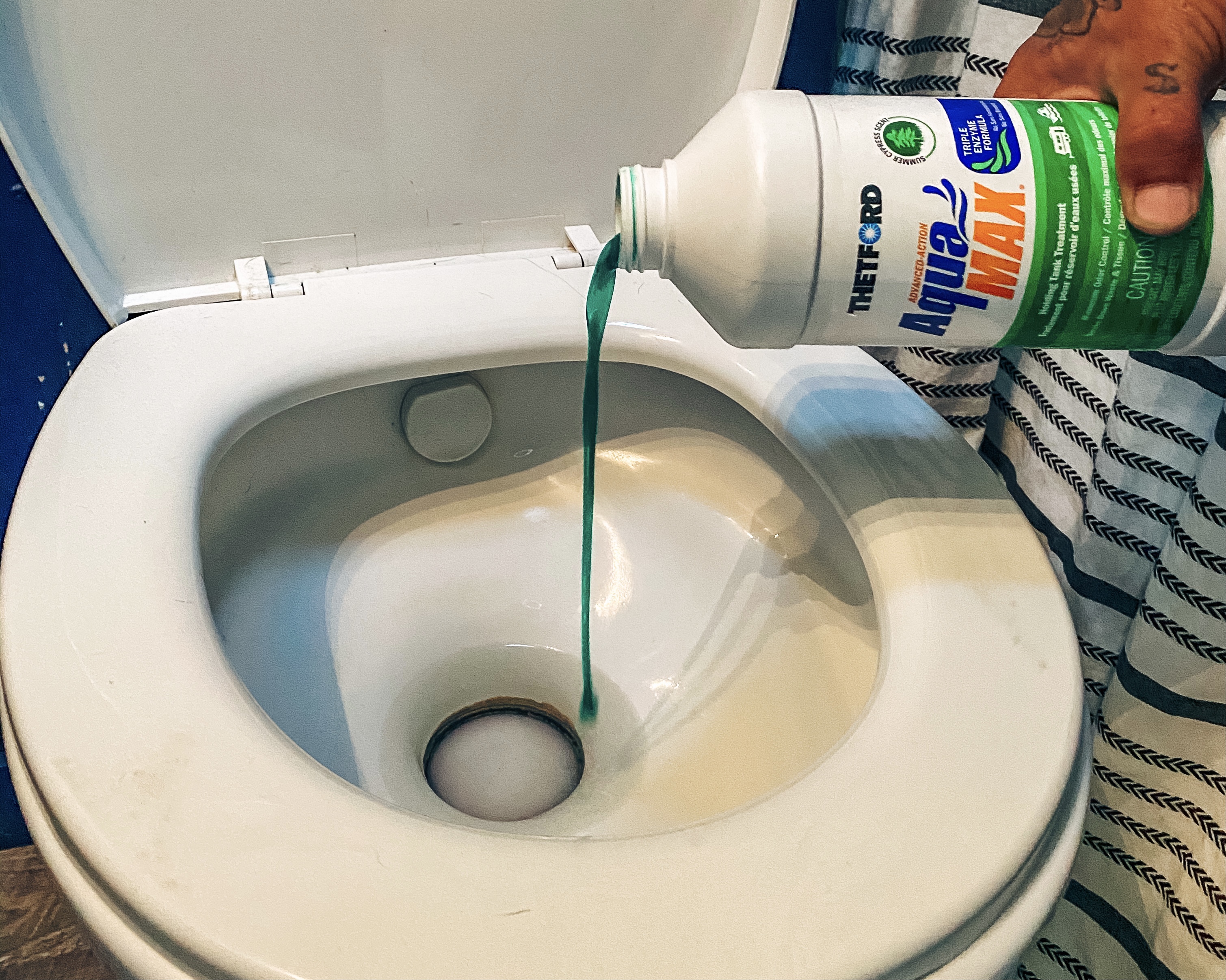 Justin Russell pouring a liquid into his RV toilet