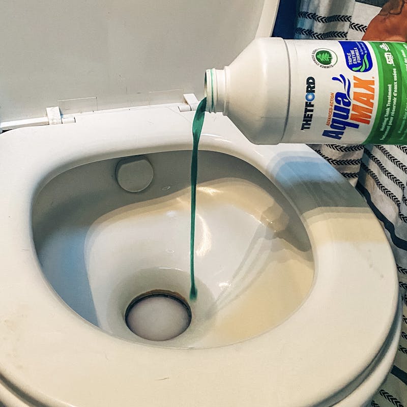Justin Russell pouring a liquid into his RV toilet