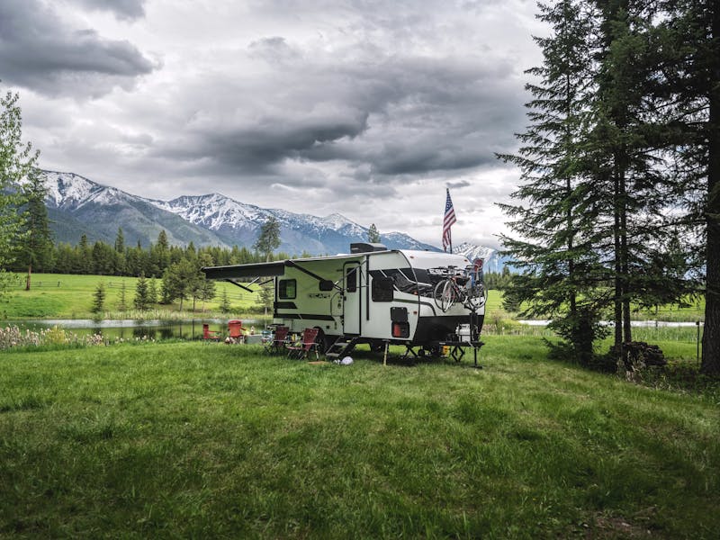 A KZ Escape camping near a small pond and snow covered mountains