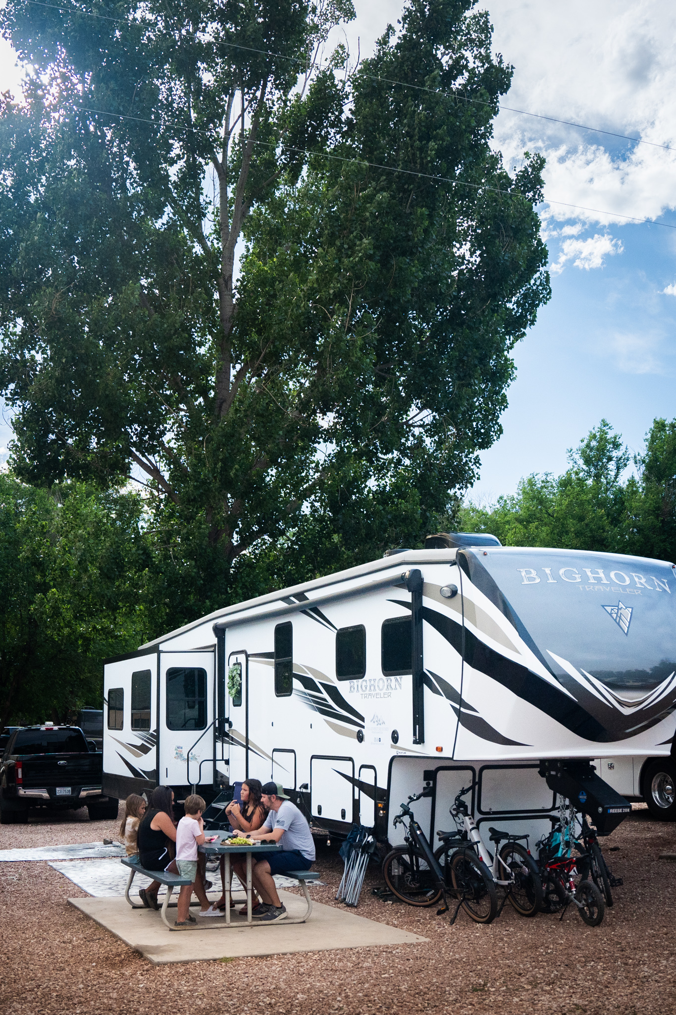 Amanda Boon and her family sitting around a picnic table outside of their Heartland Bighorn RV