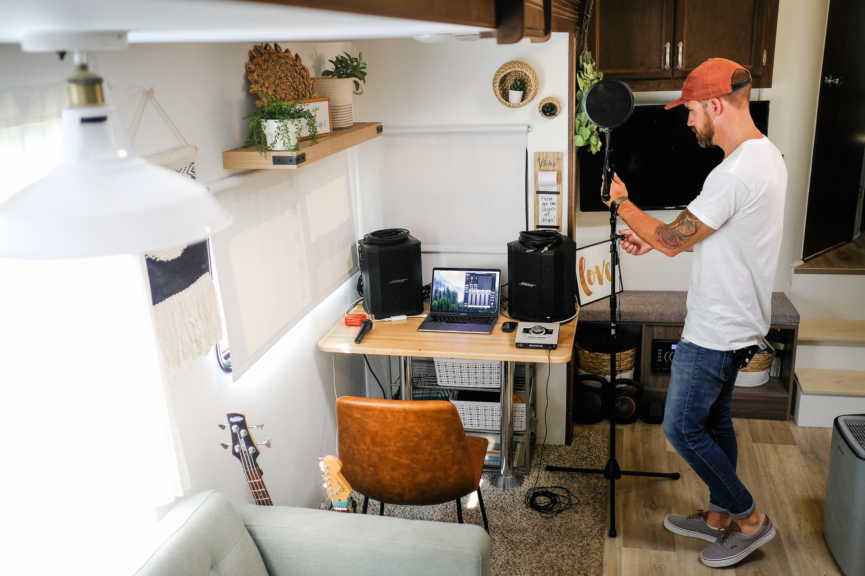 Amick Cutler sets up recording equipment inside his RV by a desk.
