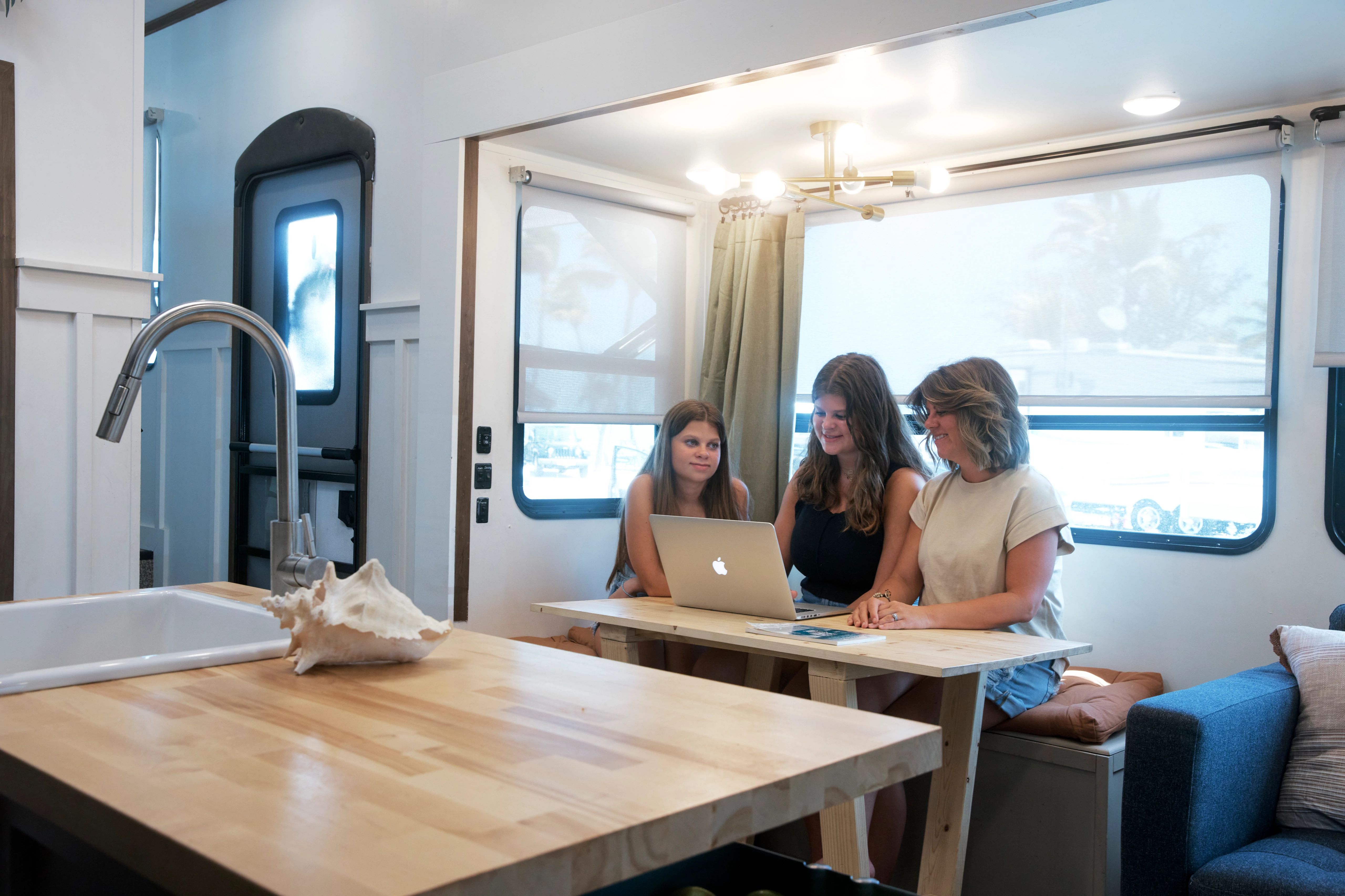Ava Lane working on the computer with her mom and sister