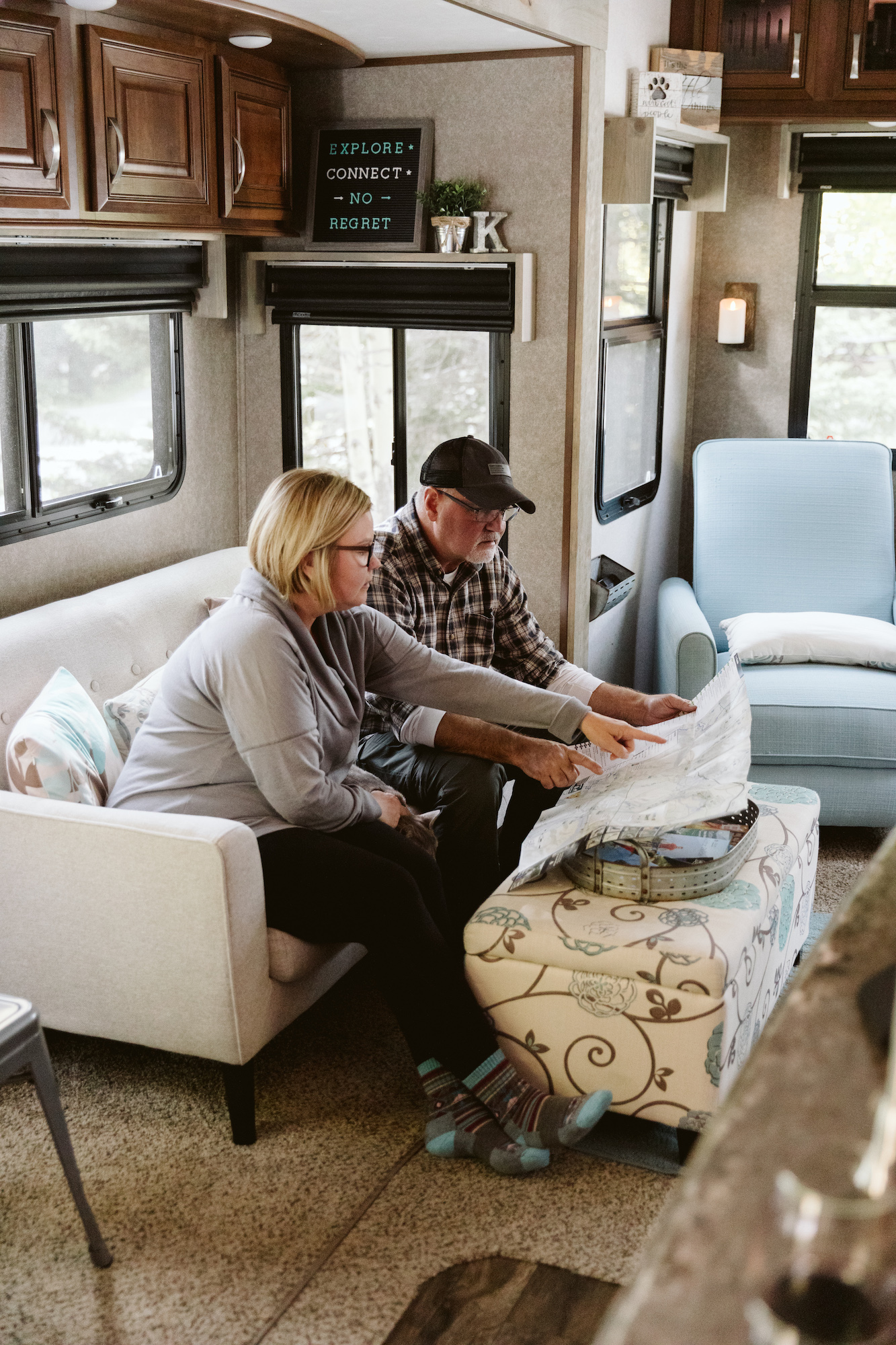 Tina and Craig sitting on a couch inside their RV, looking at a map.
