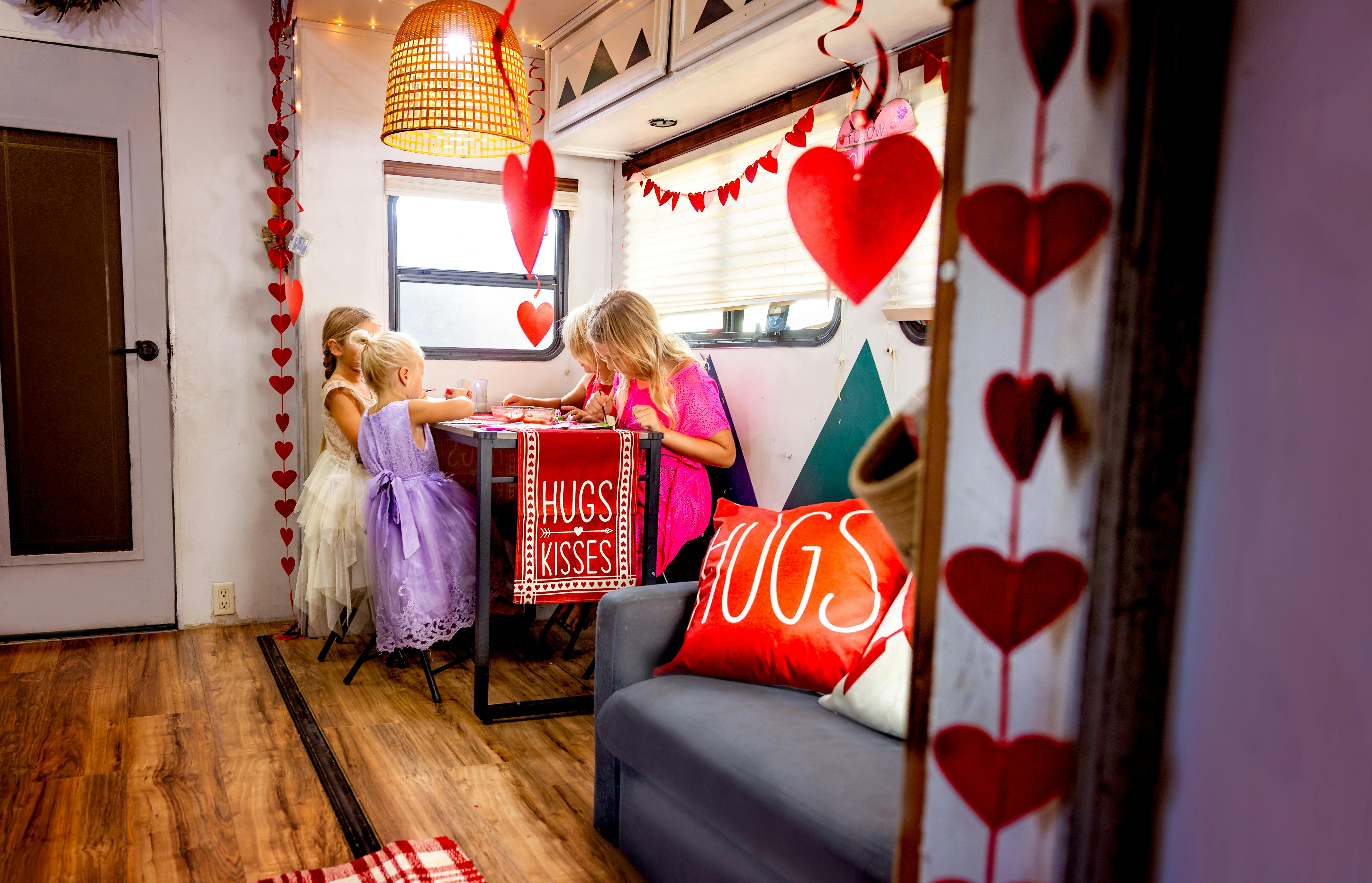 JOSH & CASSIE BAILEY's children making valentines day decorations inside their RV
