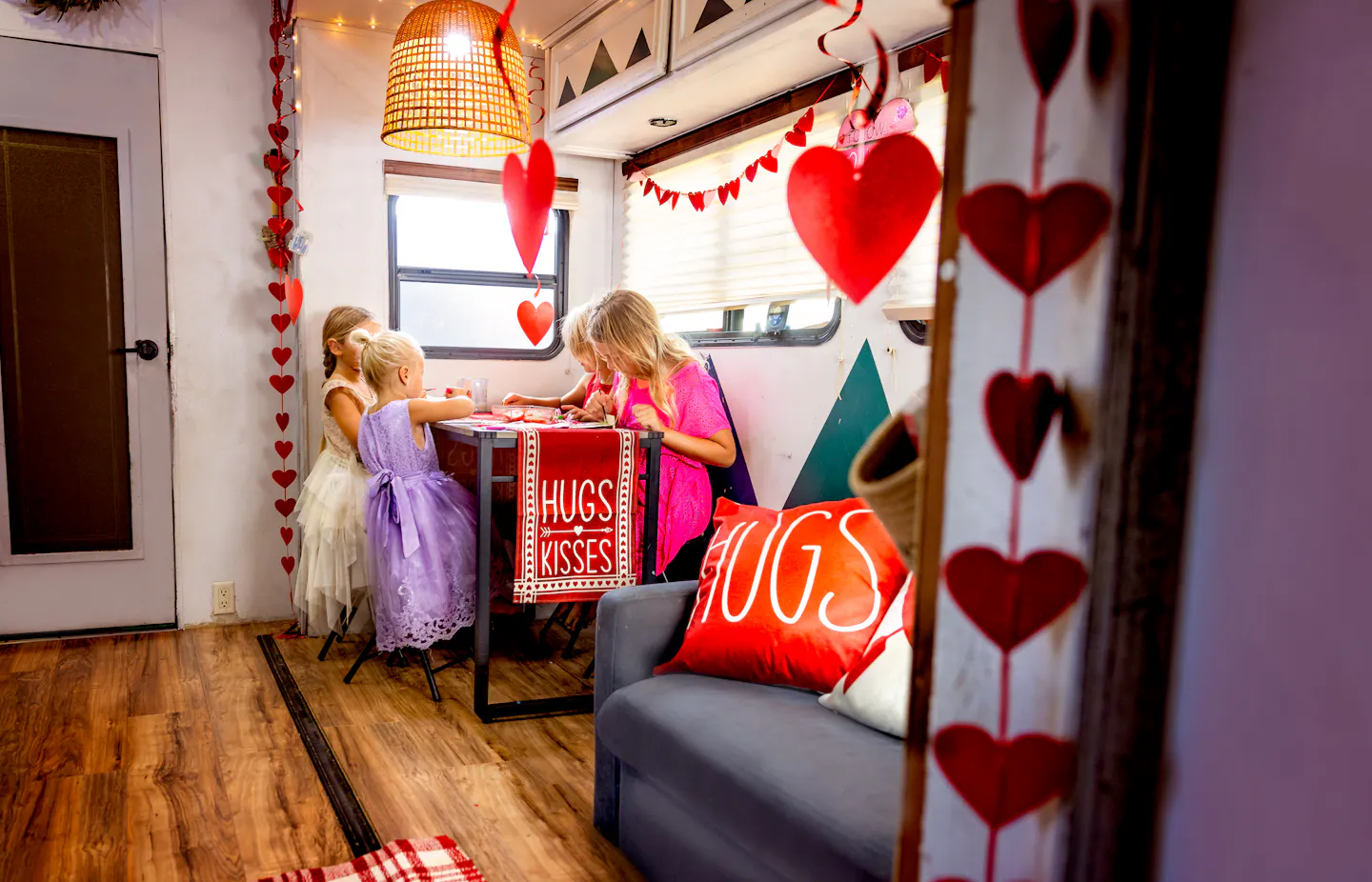 JOSH & CASSIE BAILEY's children making valentines day decorations inside their RV
