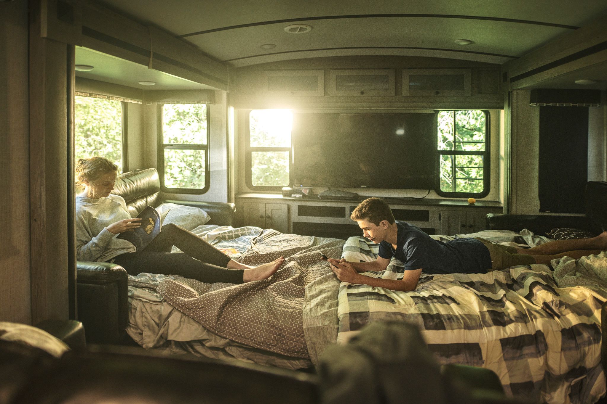 keystone outback travel trailer children sitting on pull out couches in front of a tv