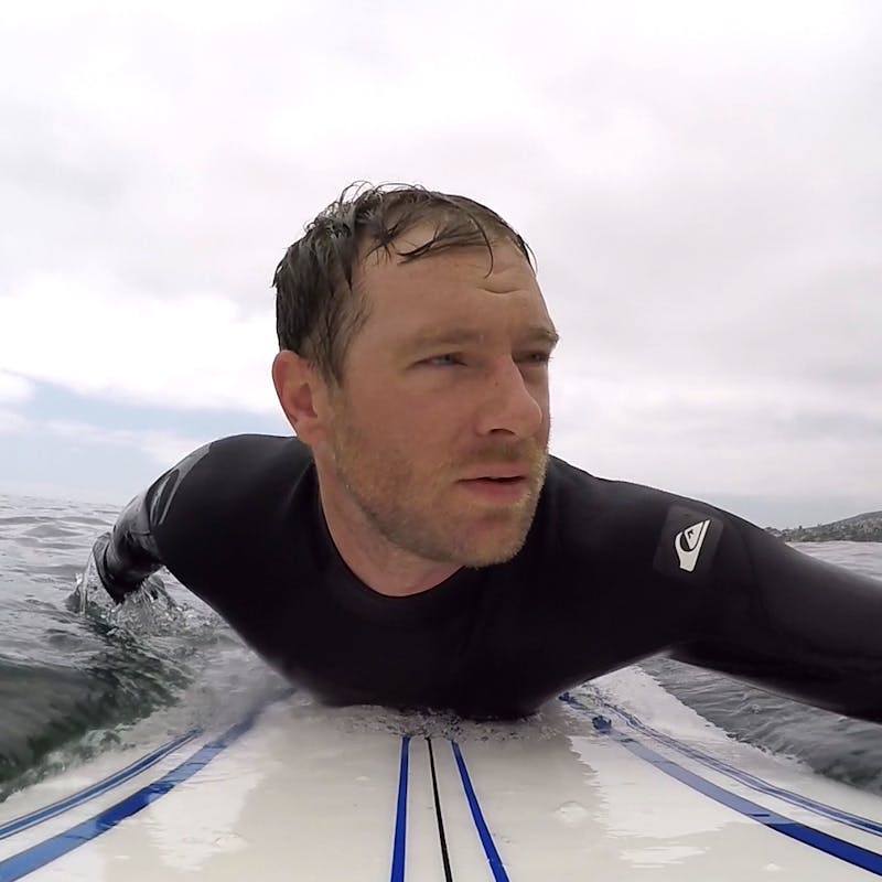 Eric Hannan paddling out to surf.