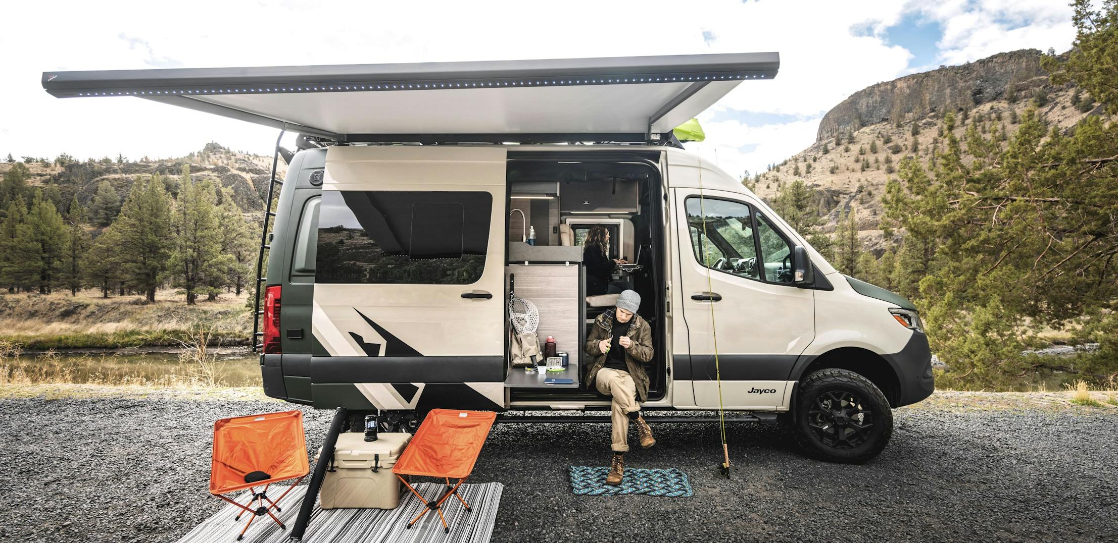 A man with fishing equipment outside a Jayco Terrain 