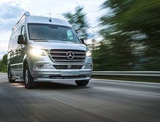 A Class B RV drives down the road.