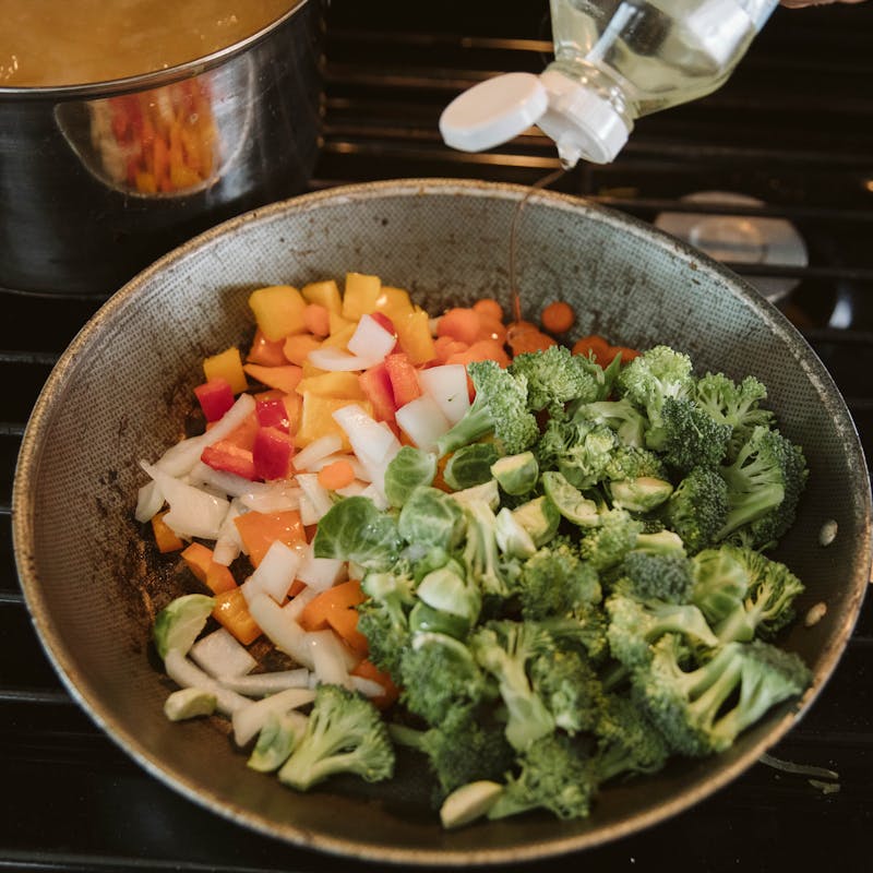 A saute pan full of cooking vegetables.