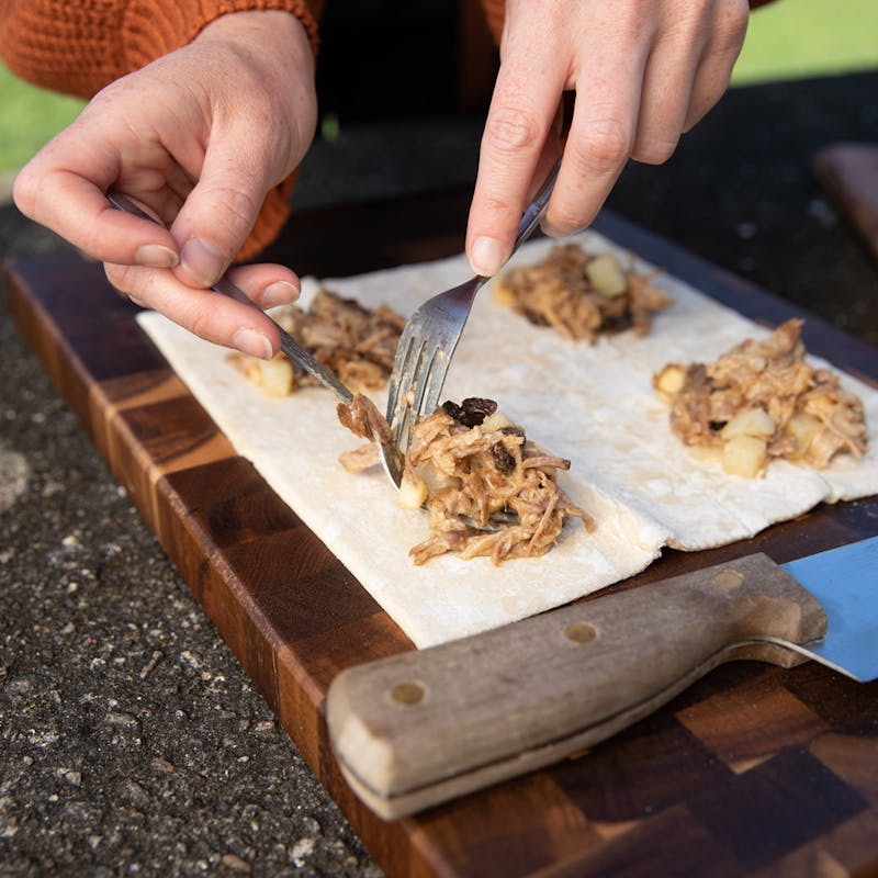 Placing leftover pulled pork on pastry dough to make hand pies.
