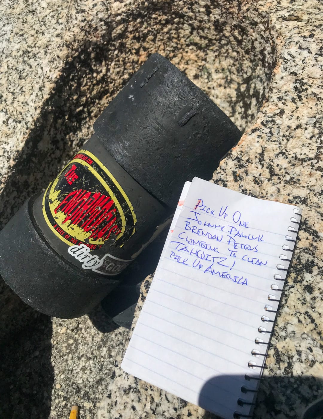 Black container to collect trash and notepad with blue ink notes