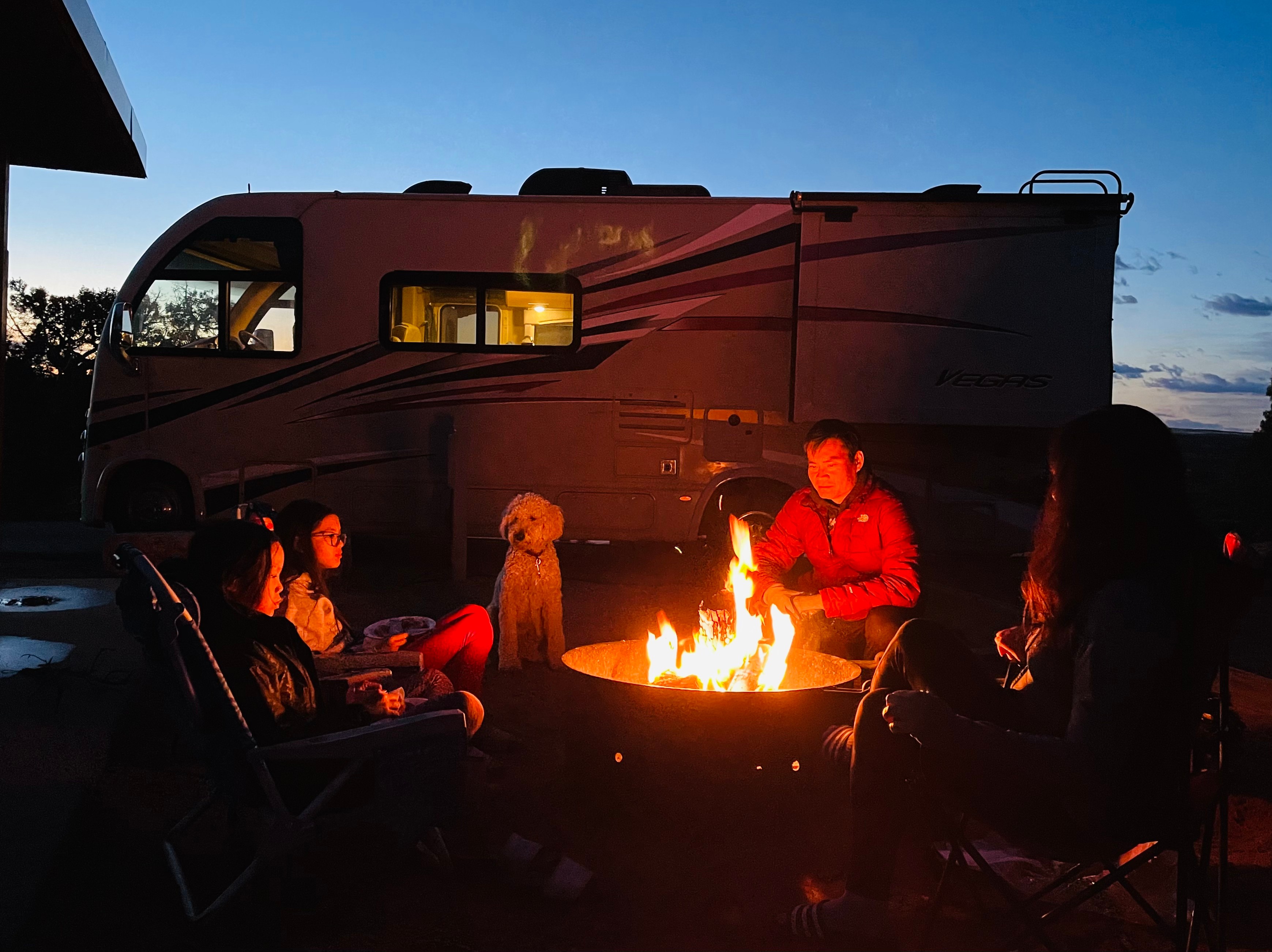 Brenda Huynh & Tiger Doan sitting around a campfire with their family