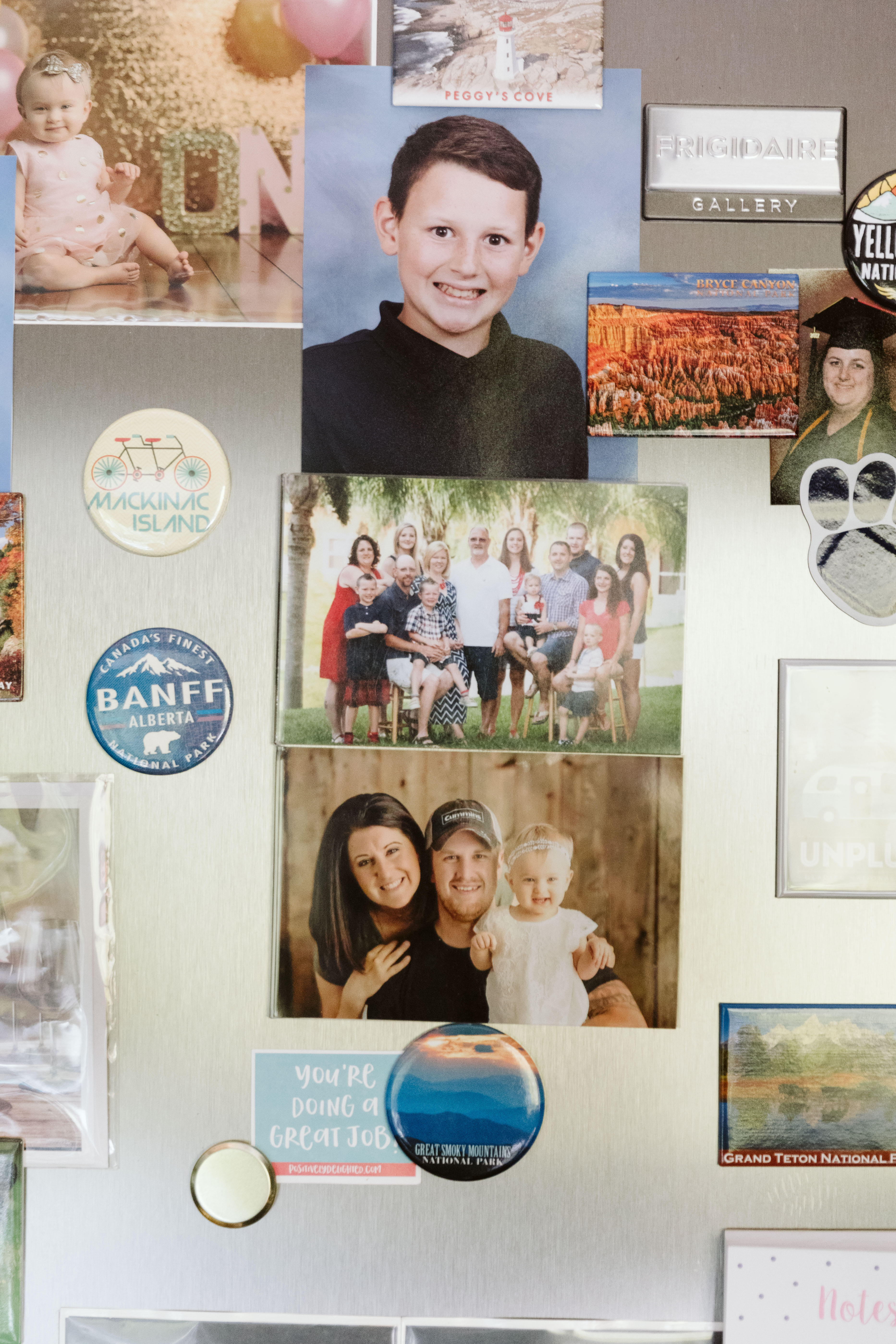 Family photos stuck to a fridge. 