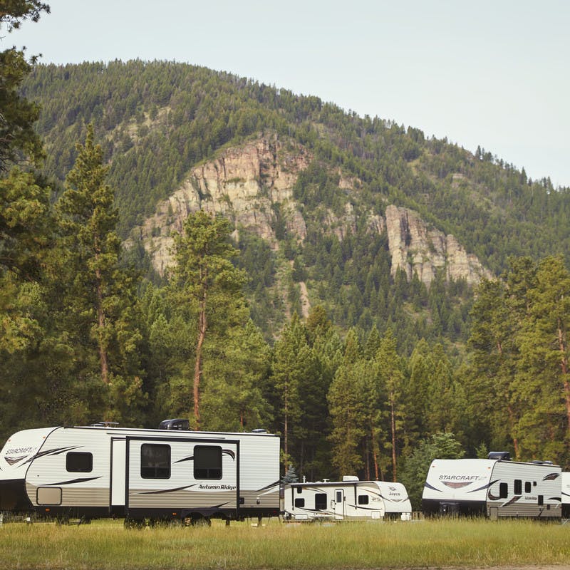 Travel trailers sit in front of a mountain on Cliffs Ranch near the Blackfoot River in Montana.
