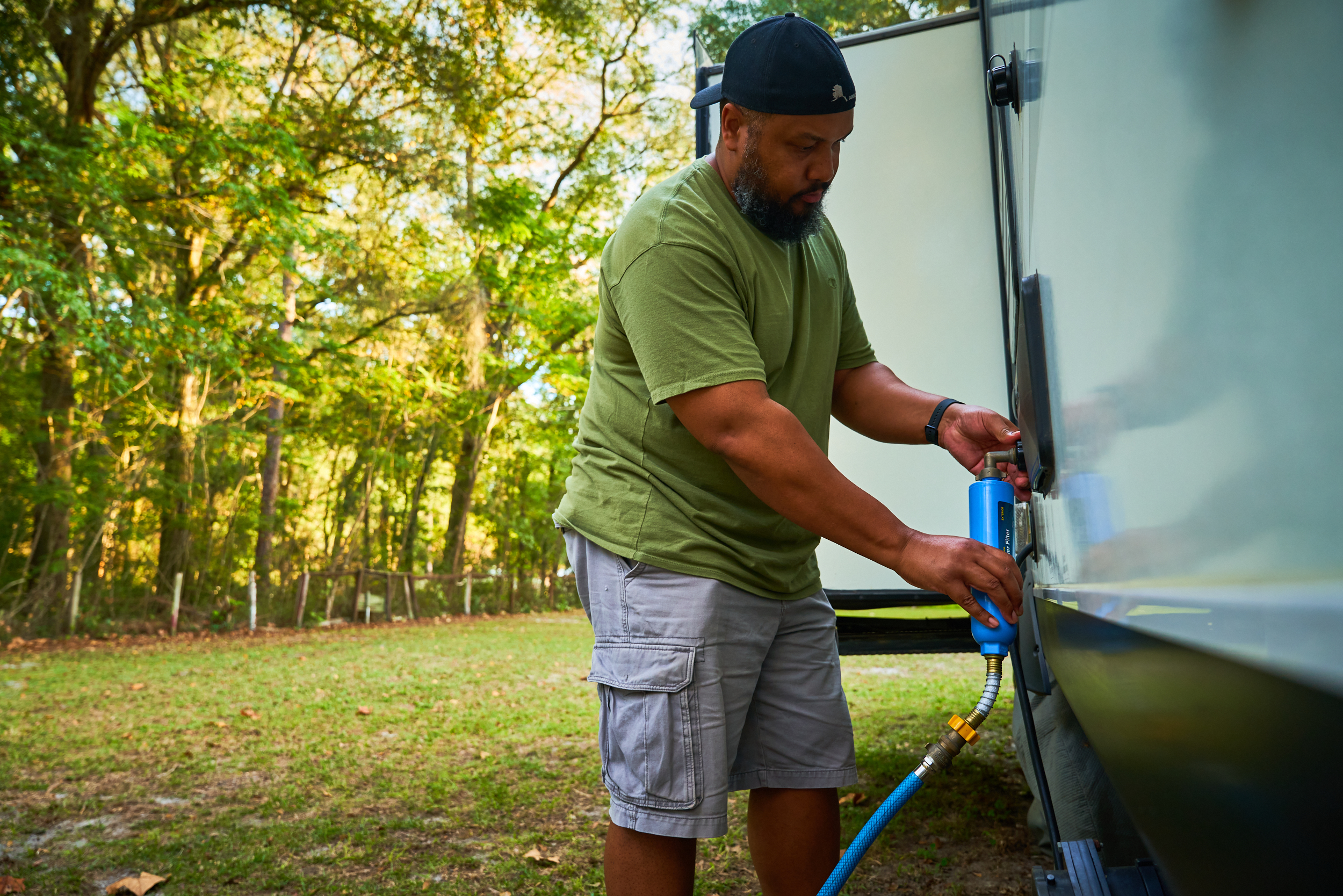 Ben McMillan connecting a water hose to his RV