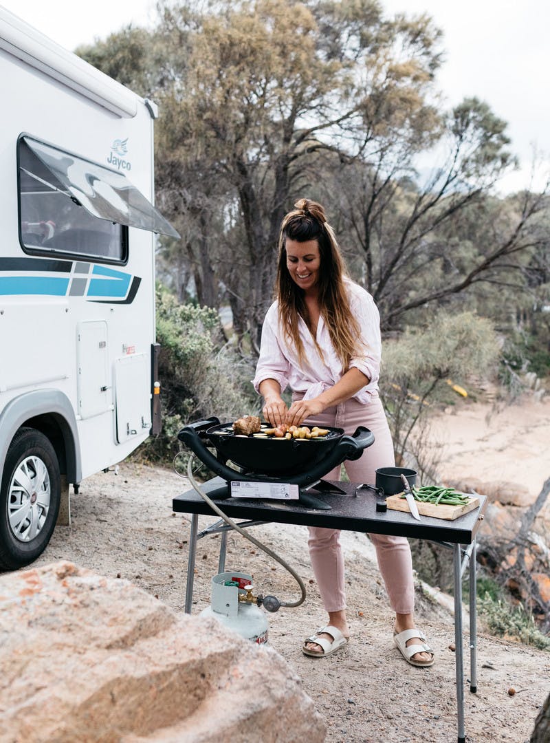Sarah Glover grilling outside Jayco Class C motorhome.