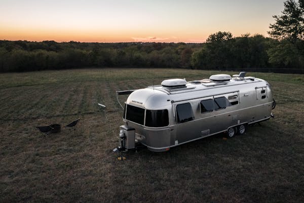 Karen Blue's airstream boondocking in a field at dusk