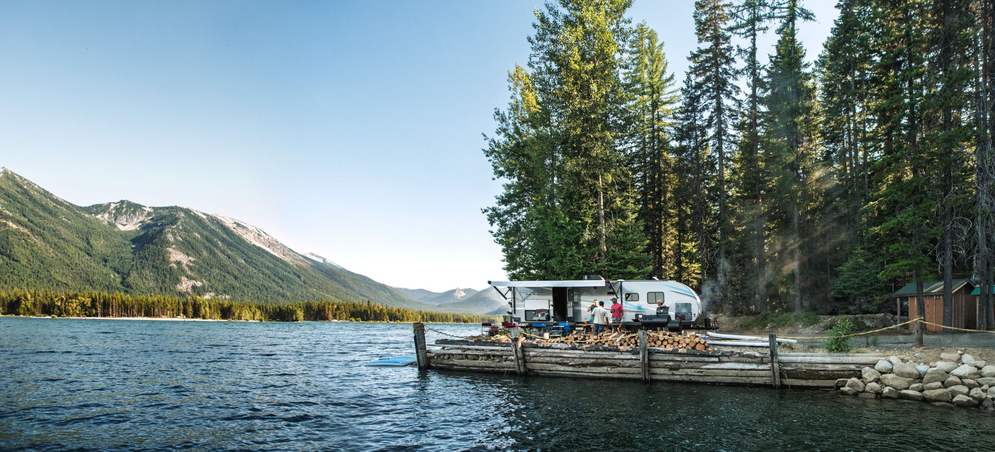 A KZ connect travel trailer camping near a lake in the pacific north west
