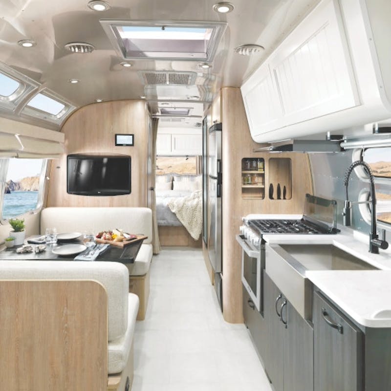 The interior of an Airstream Pottery Barn, featuring a dinette and kitchen.