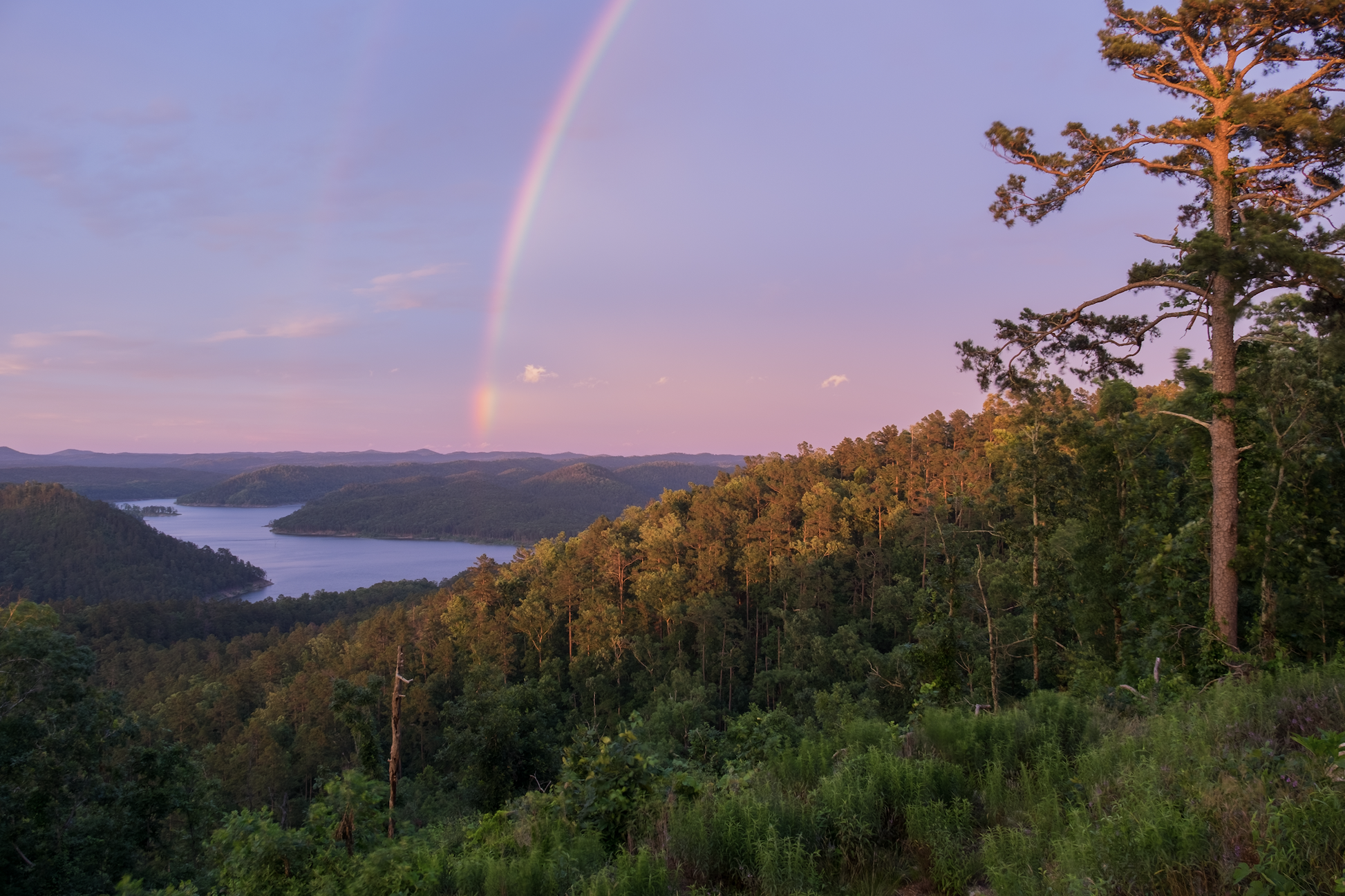 A Brilliant Rainbow at Sunset over Mountain Lake in Beavers Bend State Park