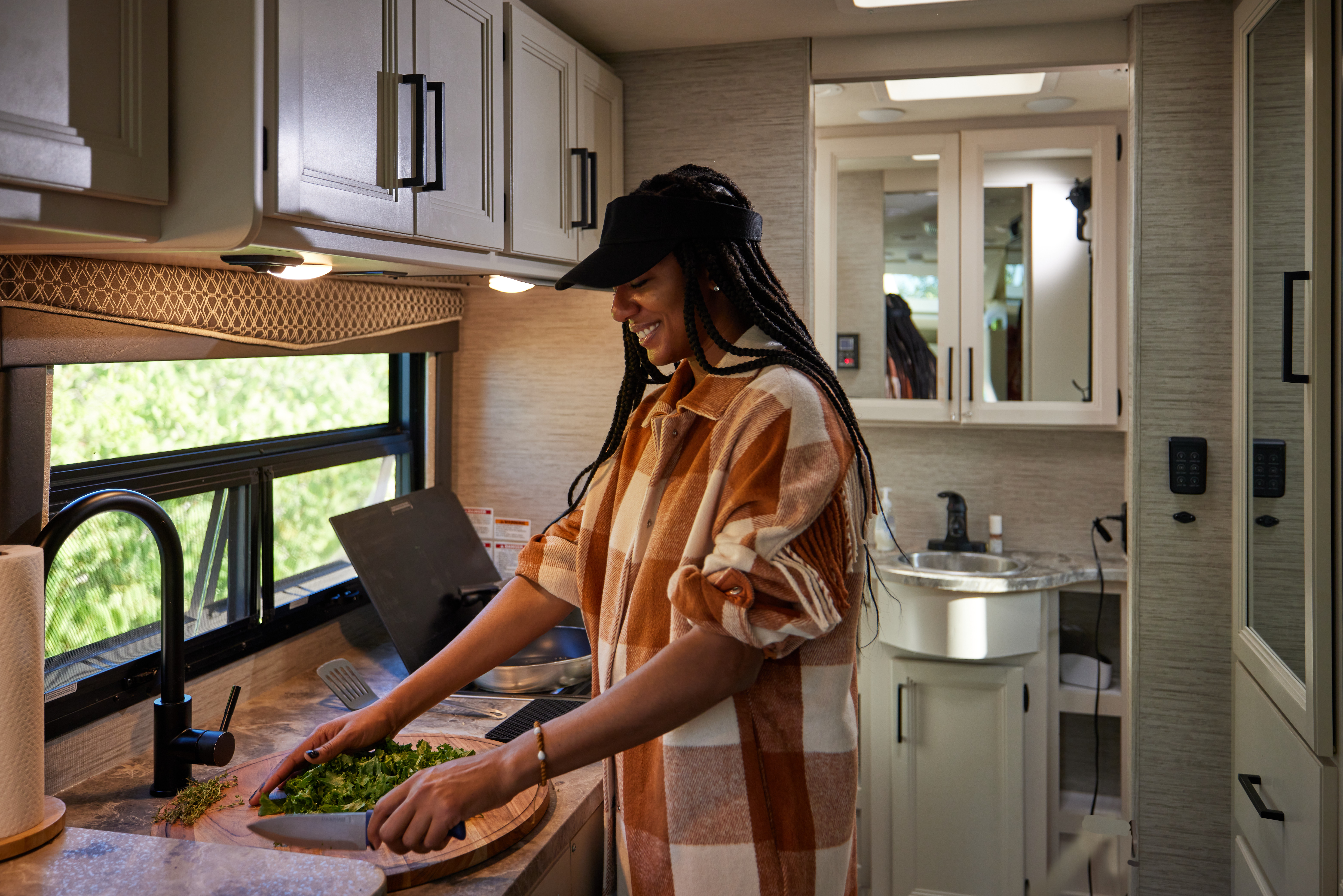 Travel writer Adrienne Jordan cooks dinner inside a Thor Motor Coach Gemini Class B+ Motorhome.