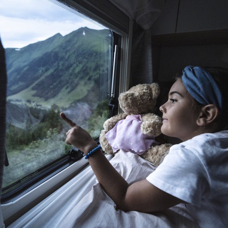 Little girl points out of the window for her family's Class B RV by Hymer.