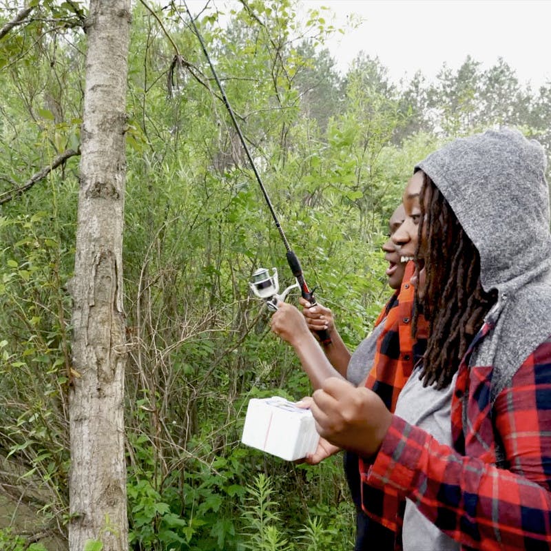 Chanel and Brittany Tate fishing by a river.