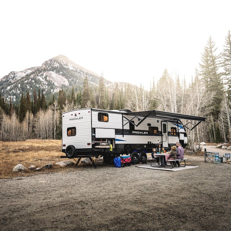 A family eating at a picnic table by a mountain