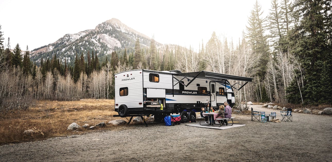 A family eating at a picnic table by a mountain