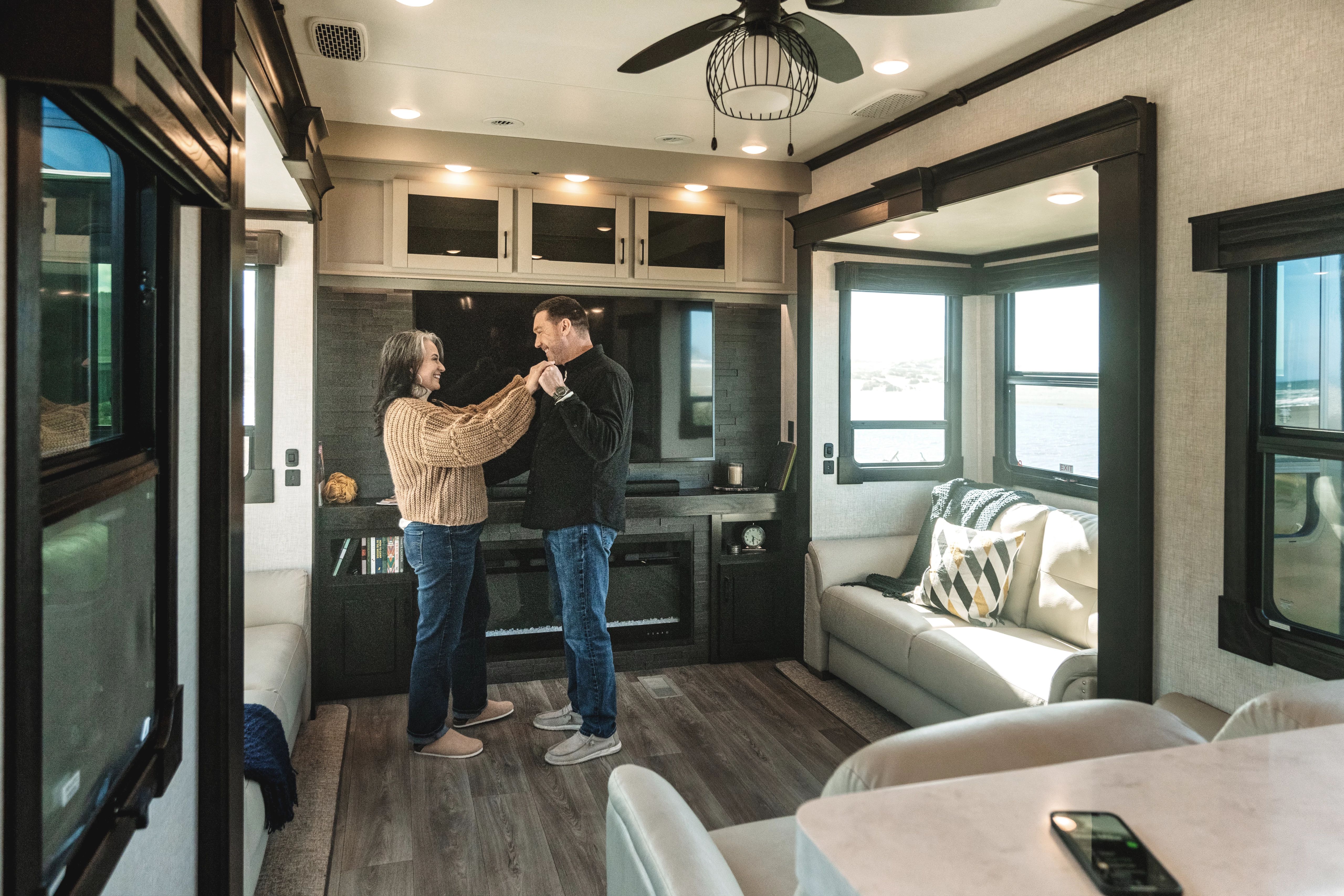 A couple dancing in the living room of a fifth wheel