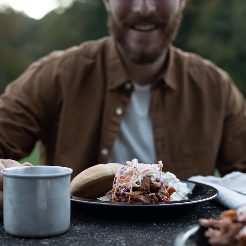 A barbeque pulled pork sandwich on a plate, piled high with coleslaw.