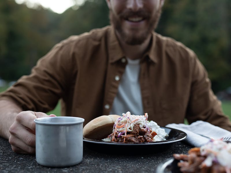 A barbeque pulled pork sandwich on a plate, piled high with coleslaw.