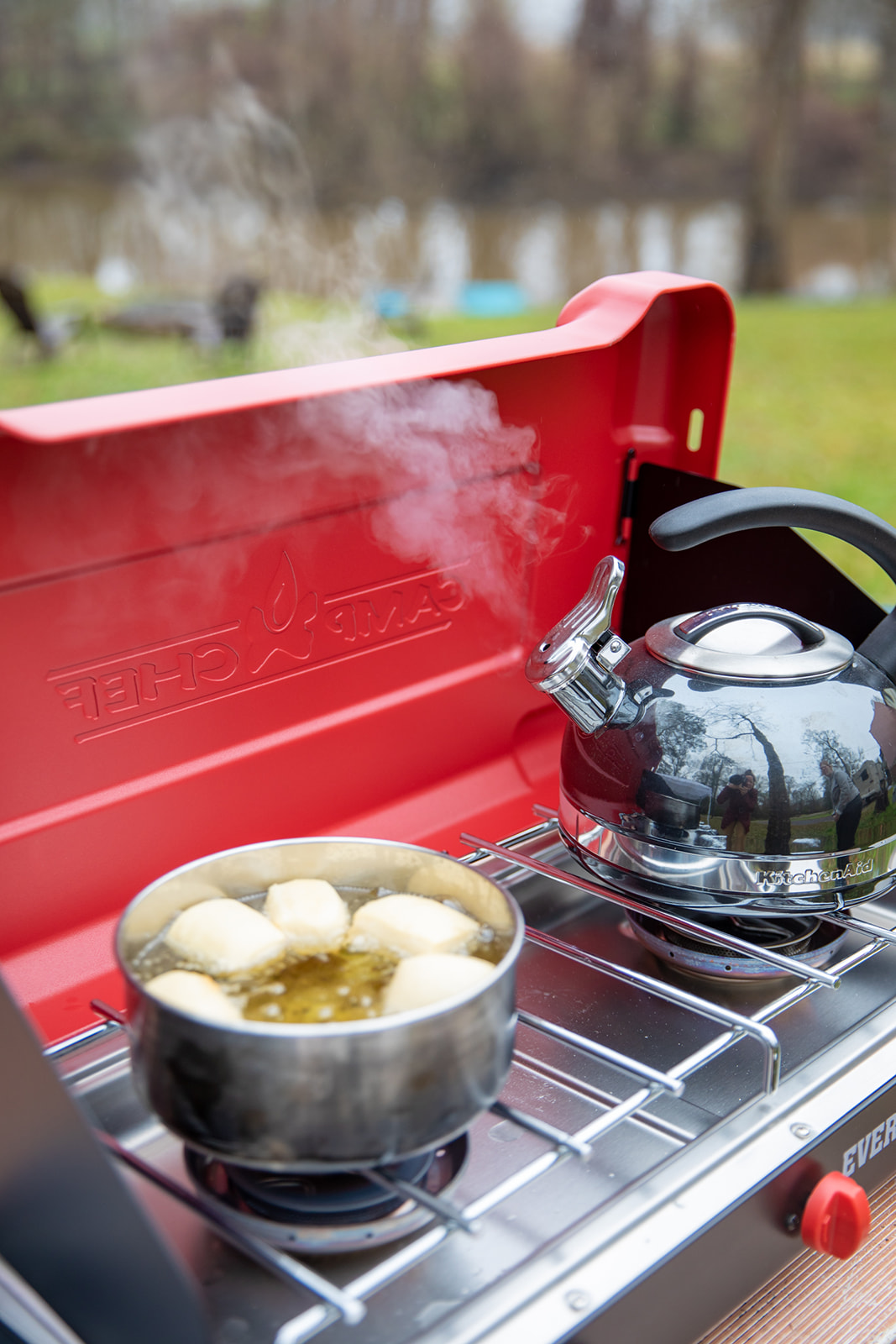 Heating water for coffee while beignets fry in a pot of oil. 