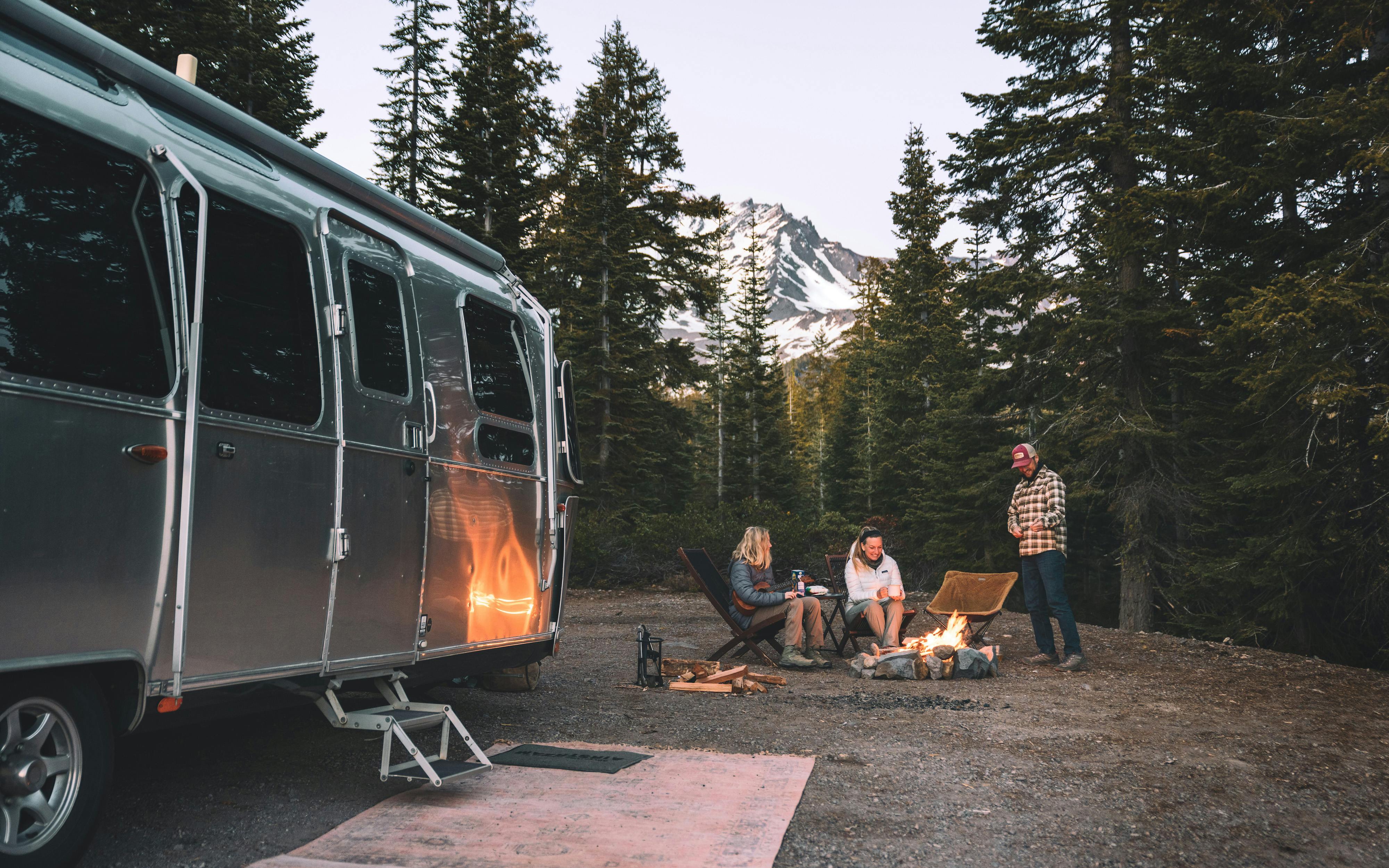 Karen Blue and her family sitting around a fire while boondocking in a forest